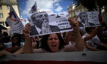 Portugals offentlige sektor er hårdt ramt af sparekrav, og selvom landet er den pæne dreng i klassen af EUs mest gældstyngede
lande, er stramningerne ikke gået stille hen. Her er det lærere,
der protesterer, blandt andet med et budskab til undervisnings-
minister Nuno Crato: Retfærdigheden venter dig.
Foto: Francisco Seco/AP Photo/Polfoto