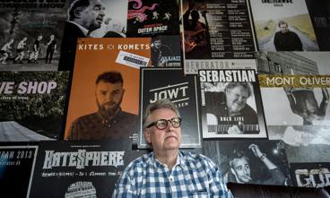 Daglig leder Anton Bjerg sidder i backstagerummet på spillestedet Generator. Over ham hænger plakater fra et par af de kunstnere, der hat stået på scenen de seneste otte år.