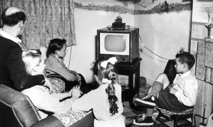 Stor familie. Lille skærm. Billedet er fra 1957 og tager nok pointen lidt til ekstremer. Men da mor var ung, var fjernsyn altså noget, der samlede familien. I dag er konceptet modsat: En skærm til hver. Men tv er stadig et godt emne, når der hyggesnakkes i pauserne på jobbet, konstaterer Suzanne Moll.